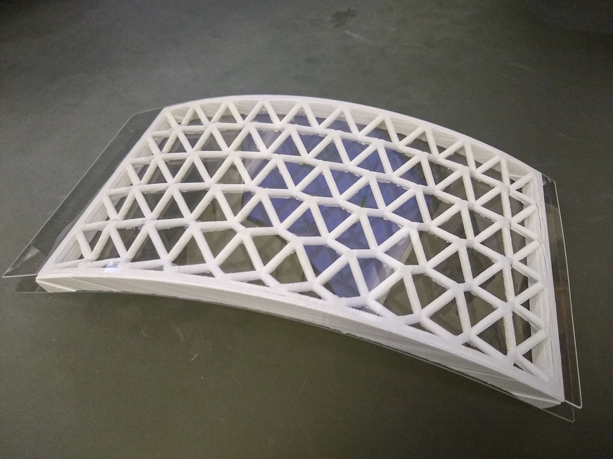 04: Das Muster eines gekrümmten Verbundelements mit 3D-gedrucktem und eingeklebtem inneren Kunststoffkern bei einer gebogener Glaseinheit.