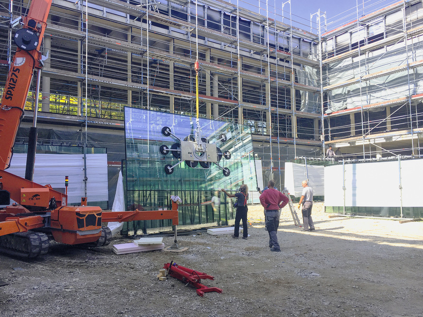 Bei der Montage der Fassadengläser erleichtertete Hebetechnik den Einbau der schweren Scheiben.