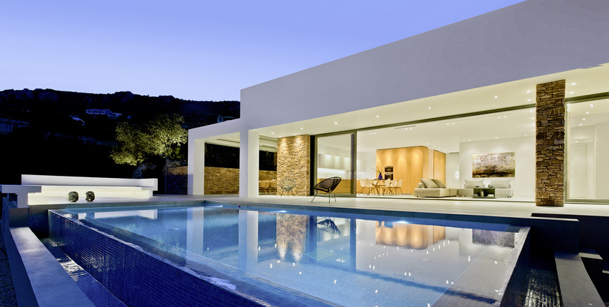 Direkten Zugang vom inneren Wohn-/Essbereich zu Pool und Terrasse ermöglicht ein raumhohes Schiebesystem von ca. 9 m Breite und 3 m Höhe.