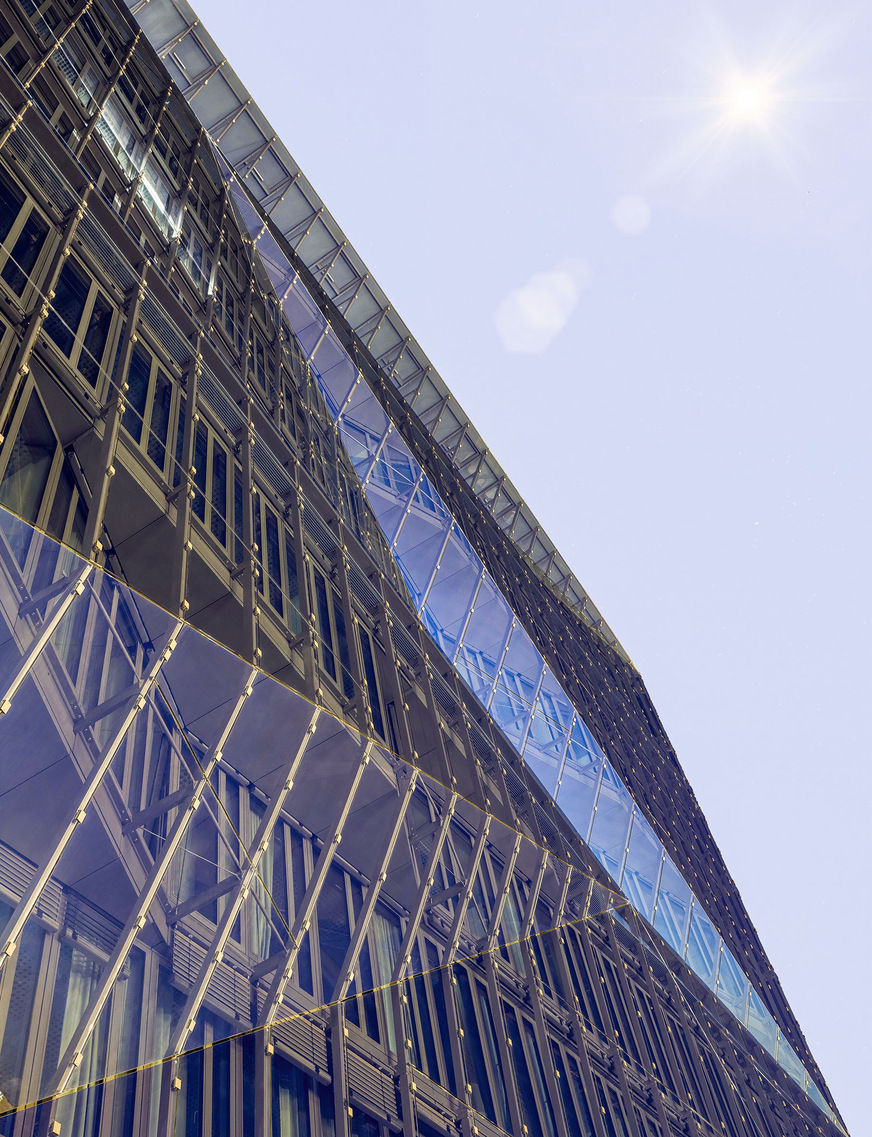 Die prismenförmigen Glasflächen spiegeln die Umgebung und lassen das Gebäude ständig anders aussehen, je nach Blickwinkel, Wetter und Tageszeit.