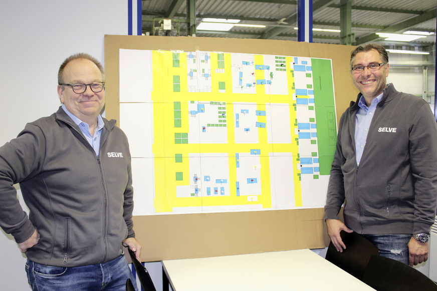 So könnte die Lüdenscheider Produktionshalle aus­schauen: Ein komplett neues Design der einzelnen Fertigungs­linien wird derzeit erarbeitet. Vinken (li.) und Solzbacher (r.) haben bereits ­etliche Prozessverbesserungen auf den Weg gebracht und noch ­weitere wesentliche Veränderungen im Blick.