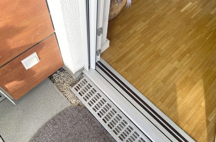 Wolfgang Klug wollte keine ca. 12. cm hohe Schwelle zwischen Balkonboden und Schwellenoberkante. Die vorherige 2012 erbaute Türschwelle wurde 2016 komplett zurückgebaut und konnte mit einer Magnet-Nullschwelle für den Neubau ersetzt werden. Nun kommt seine Frau ohne Hilfe selbstständig auf den Balkon.