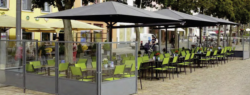 Großschirme werden gerade in der Gastro­nomie ein immer wichtigerer Teil der Gesamt­lösung. Dabei ist ein Windschutz eine opti­male Ergänzung.