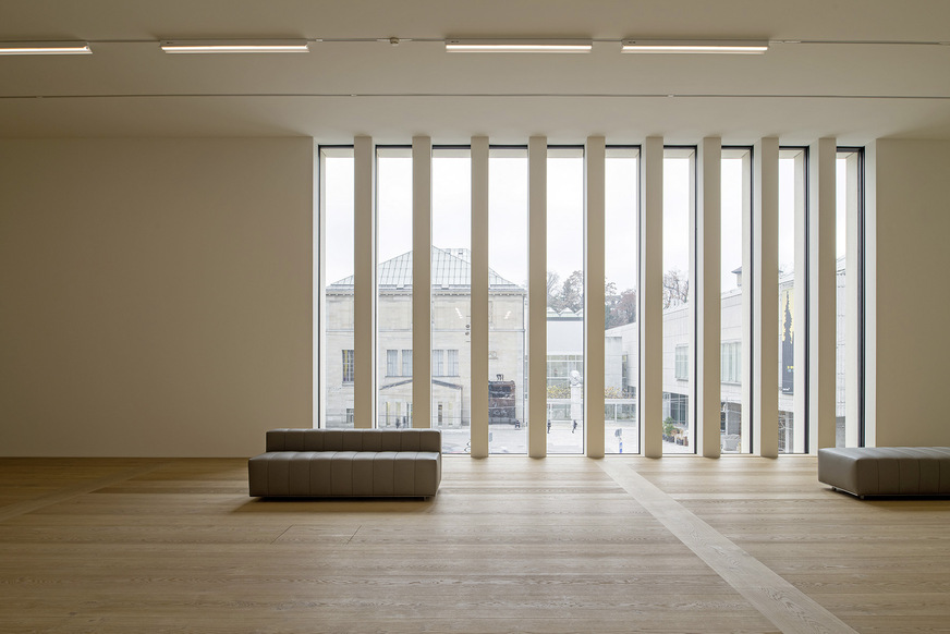 In den Ausstellungsräumen lassen raumhohe Fenster und im obersten Geschoss zusätzlich auch noch Überkopfverglasungen viel natürliches Licht ins Gebäudeinnere.