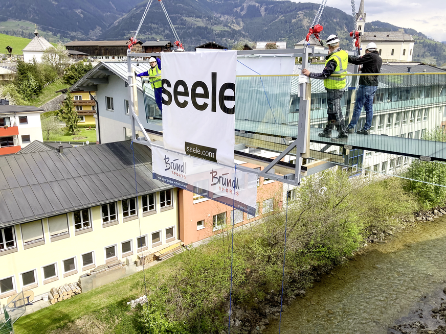 In 15 m Höhe demontieren die Monteure von seele nach der Fixierung des Glasstegs den Montagerahmen.