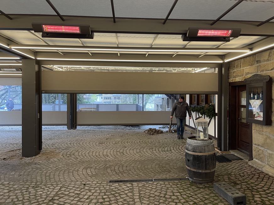 Rund 120 Quadratmeter der Außengastronomie können mit durchsichtigen Seitenbehängen komplett geschlossen, beleuchtet und beheizt werden. Rolf Kehrbeck vom ausführenden Fachunternehmen zeigt sich zufrieden mit dem Ergebnis.