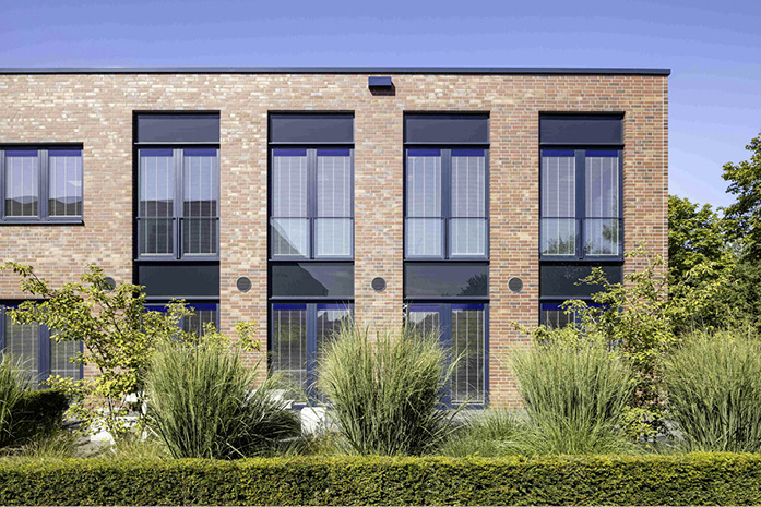 Die Fensterelemente mit dem Jalousien-Isolierglas ­Isolette bieten hohe Energieeffizienz und fügen sich nahtlos in die Klinkerfassade des Spaleck-Gebäudes ein.