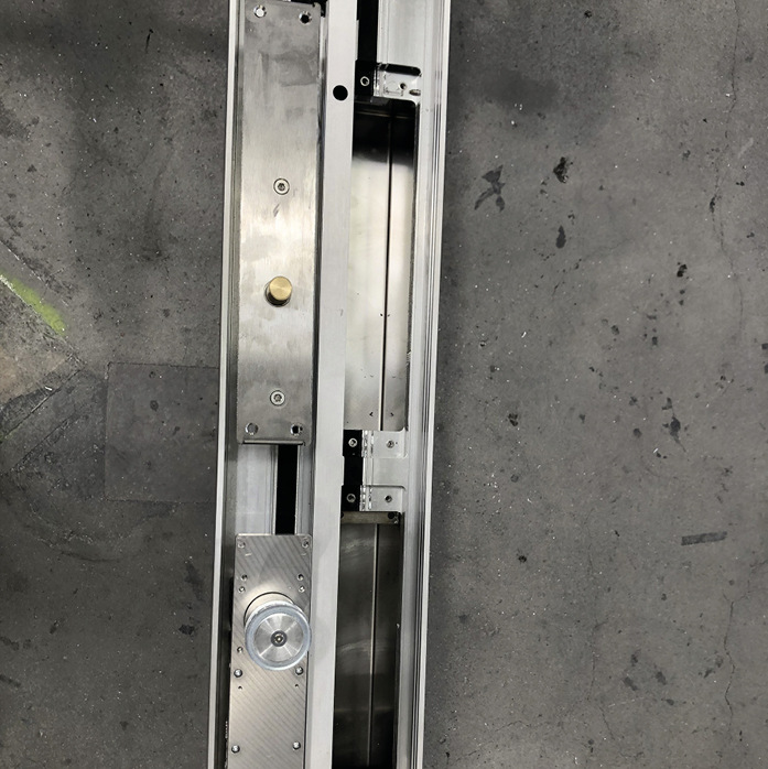 Hier zu sehen das Kopfprofil eines Fensterelements mit den vorbereiteten Ausschnitten für Verriegelung und Antrieb. Aus beiden Öffnungen wird die Bauform der Motor-Antriebseinheit des ISA1 ersichtlich.