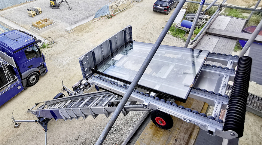 Die kippbare Pritsche des Aufzugs ermöglicht die komfortable Entnahme der Fenster. Mithilfe der Rollenleisten und umschäumter Rollen (rechts im Bild) werden die Fenster sicher transportiert und lassen sich von den Monteuren schnell entladen.