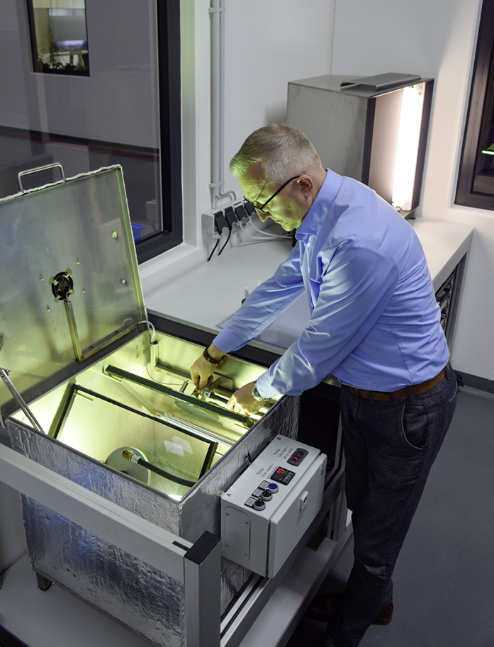 Behutsam werden die Prüfscheiben in der Fogging-Box platziert. Beim anschließenden Anbringen der Kühlplatten wird besonders sorgfältig darauf geachtet, dass diese auf den Glasoberflächen ihren absolut ebenen Sitz finden, um optimale Testergebnisse zu erzielen.