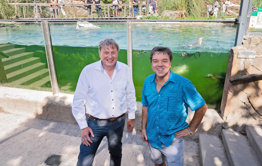 Der Direktor des Krefelder Zoos, Dr. Wolfgang Dreßen (r.), mit dem Vertriebsleiter Vetrotech Saint-Gobain Deutschland, vor der Panorama-Scheibe des Pinguin Pools