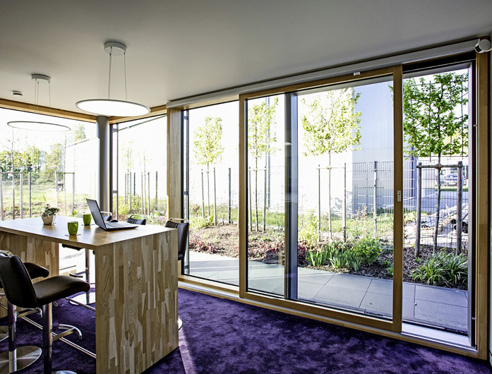 Die Hebe-Schiebe-Tür aus Aluminium-Holz ermöglicht den bequemen Zugang zur Terrasse.