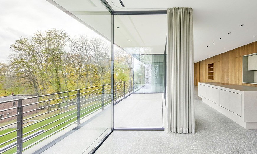 Rücksprünge in der Glasfassade schaffen geschützte Freisitze. In Kombination mit der Glasecke schaffen sie ein architektonisches Highlight.