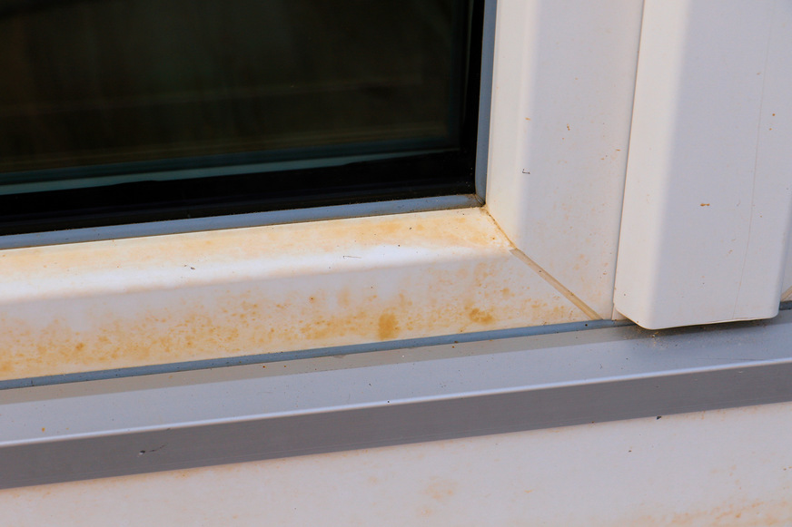 Typische Gelbverfärbung am unteren Flügelprofil eines Kunststoff-Fensters. Die Gelbverfärbung endet seitlich auf der Höhe der Schweißnähte.