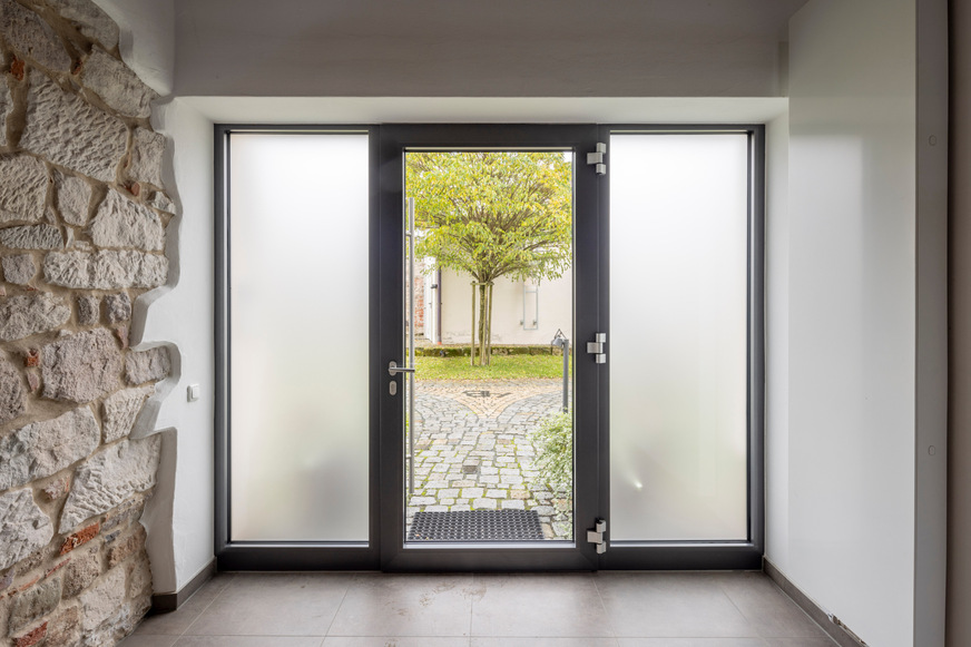 Viel Tageslicht: Das Türsystem heroal D 72 wurde in der Alten Brauerei mit einer Türfüllung aus Glas sowie Seitenteilen aus Milchglas realisiert.