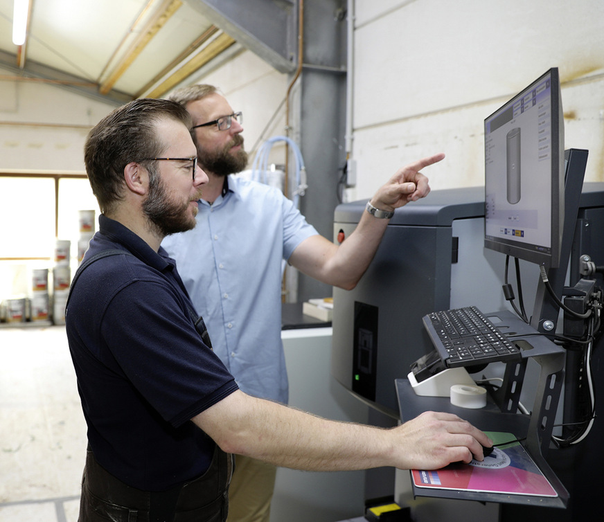 Ole Stolle, Sikkens Wood Coatings Fachberater von AkzoNobel mit einem Mitarbeiter von Herbert-Fenster an der Mischmaschine.