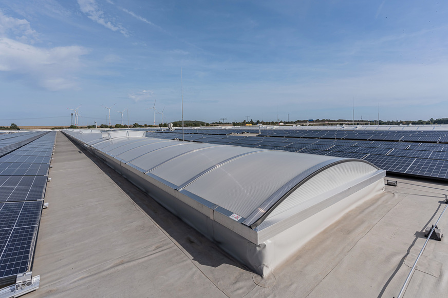 Diese Produktionshalle zeigt, wie ein Flachdach nachhaltig genutzt werden kann: Energiegewinnung durch Photovoltaik und Tageslichteinfall durch die Vario-Therm-Lichtbänder.