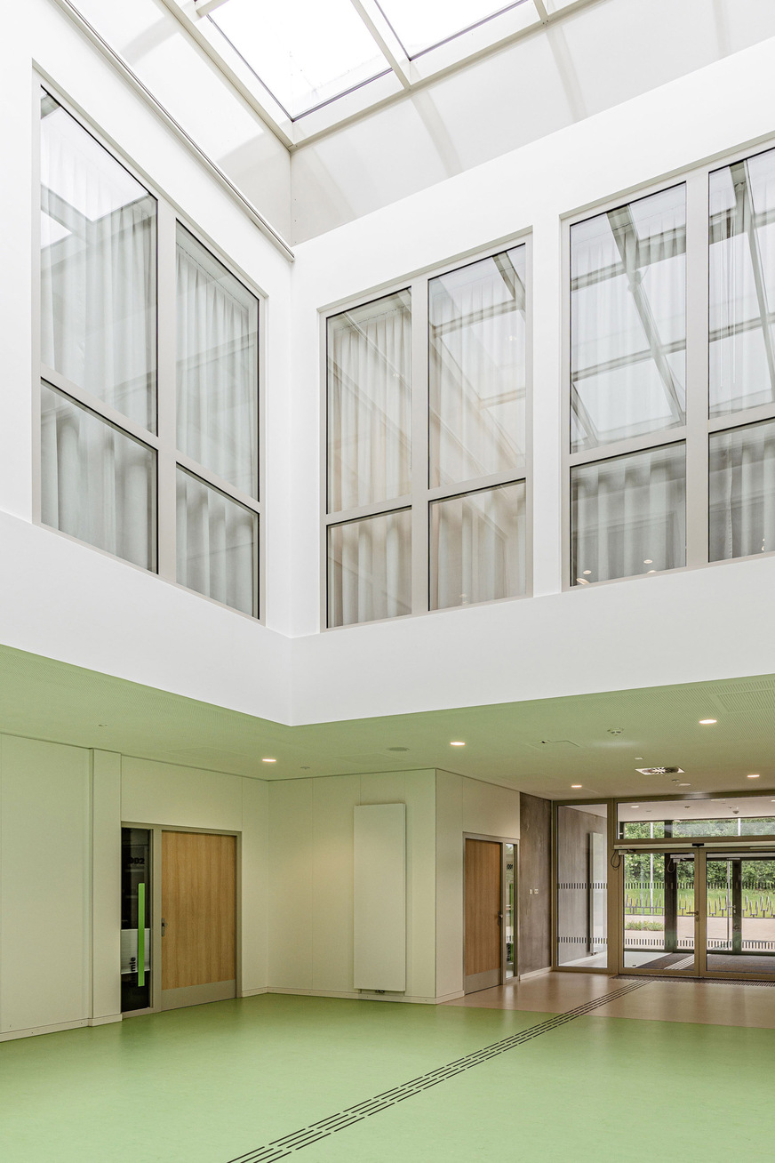 Durch großflächige Verglasungen im Innenbereich profitieren auch die angrenzenden Räume von dem Tageslichteinfall durch die Atriumverglasung im Dach.