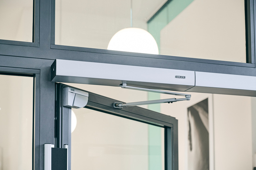 Ebenso im Einsatz: der elektromechanische Drehtürantrieb Slimdrive EMD-F/R-IS und Laserscanner GC 342 an einer 2-flügeligen Tür