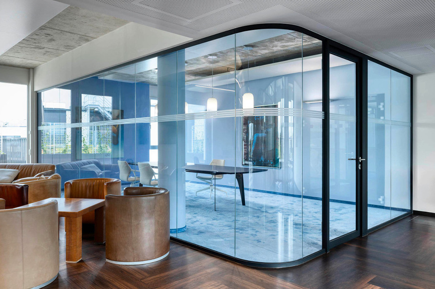 Der repräsentative Konferenzraum mit runder Glasecke ist in Blau gehaltenen.