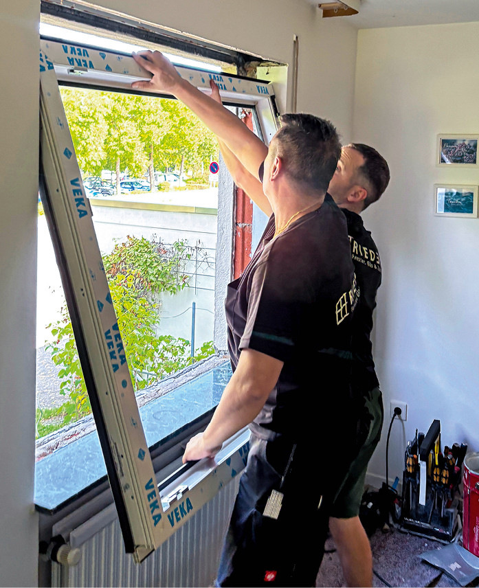Fenstermontage nach Plan: Zu zweit wird der Blendrahmen ins Loch gehoben…