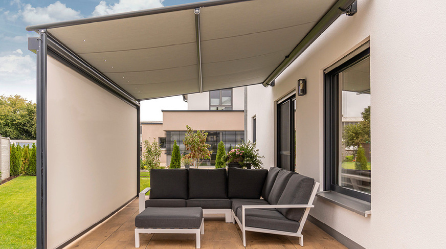 Die Pergolamarkise Viladora mit vorderer Senkrechtmarkise, die noch mehr Sicht- und Blendschutz bietet, erweitert das Wohnzimmer in den Außenbereich.