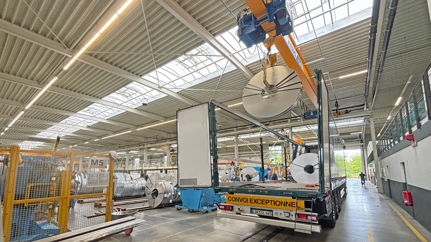 Gewaltige Stahlrollen („Coils“) dienen als Ausgangsmaterial und werden mit Spezialtransportern angeliefert.
