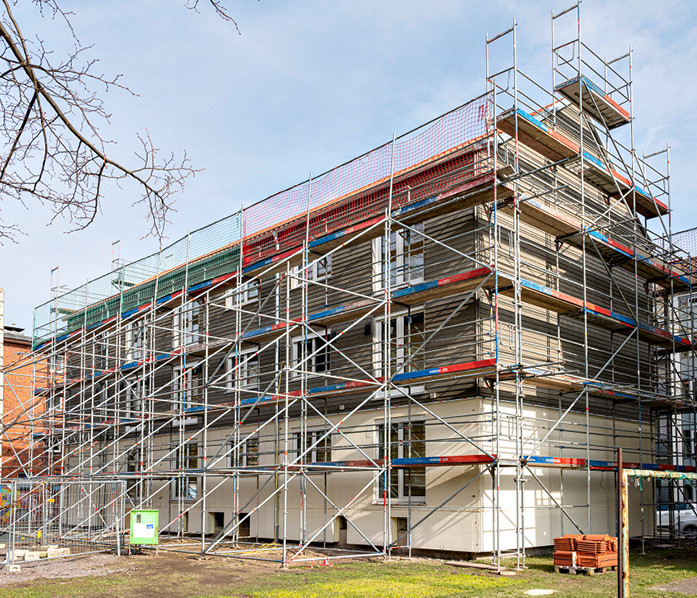 Fertige Außenfassade: Energieeffiziente Fenster mit Heizglas integriert Holzfassadenmodule.