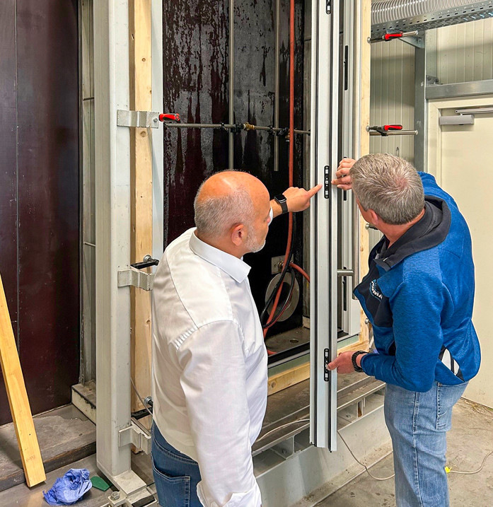 Das Thema Pivottüre bzw. die Abdichtungslösung MPI beschäftigt ALUMAT weiter (hier, am eigenen Prüfstand, re. Vertriebsleiter Henning Hild mit Account ­Manager Türschloss Johann Reiner von Maco); ­aktuell in Form einer spannenden Kooperation rund um die von KOWA entwickelte Hauseingangstüre „Fennen“ mit auf Sylt gefundenen Brettern etc.