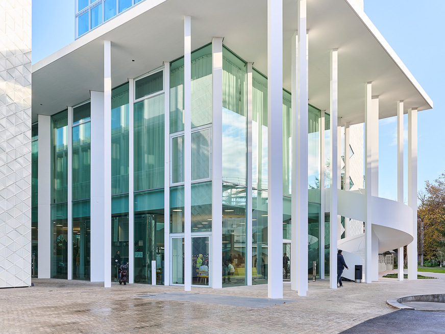 Zwischen den beiden Gebäuden wurde ein Auditorium eingeschoben, dessen Dach von 24 Stützen mit je 12m Höhe getragen wird und das raumhoch verglast ist.