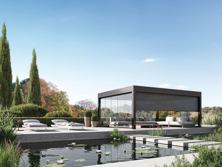 Das Somnium Dach, hier als freistehendes Lamellen-Flachdach mit zusätzlicher Ausstattung einer Senkrecht Markise des Aliplast-Partners Wilms und einer GG, Ganzglas-Schiebeanlage, ebenfalls aus dem Aliplast-Sortiment.