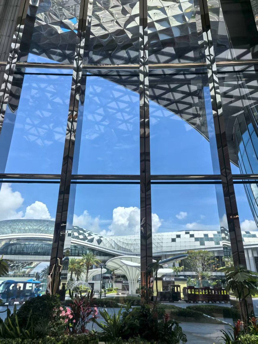 Blick durch die gläserne Fassade des Sanya International Duty-Free Shopping Complex: Die großformatigen Isoliergläser mit Ködispace 4SG eröffnen den freien Blick auf die organisch geschwungene Dachlandschaft.