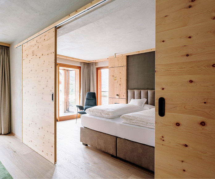 Einige der Suiten des Hotel Granvara verfügen über ­einen großen Wohnraum, der sich durch eine doppelflügelige Schiebetür von Hawa schalldämmend und lichtabschirmend vom Schlafbereich trennen lässt.