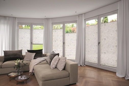 Der MHZ Plisseestoff AURELIA besteht aus 80 Prozent recyceltem Post-Consumer-Polyester. Die Qualität fügt sich mit ihrem floralen Design und zarten Grautönen hervorragend in natürlich, dezent gehaltene Wohnräume ein.