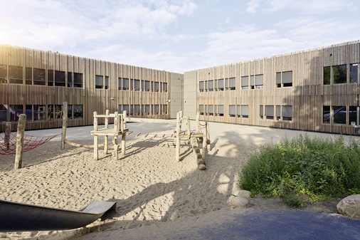 Die für die Verschattung gewählten Raffstoren führen die Lamellenstruktur der Holzfassade am Fenster fort und verstärken so das einheitliche Erscheinungsbild des Baukörpers.