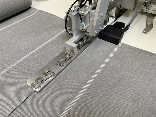 Mit einem speziellen Führungsautomaten werden die Gewebebahnen für die Stoßnaht zusammengeführt und mit einem speziellen Klebeband verklebt. Die Jentschmann-Anlage kann Stoßnähte als auch Überlappungsnähte verarbeiten.