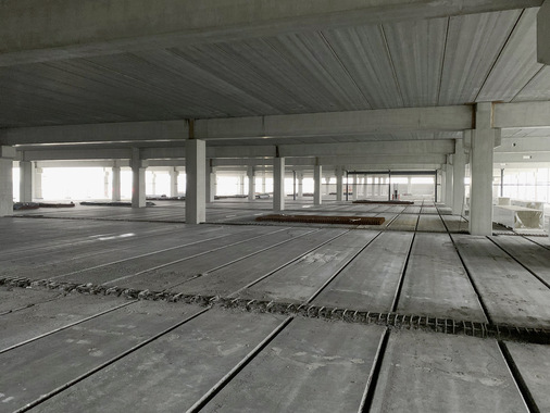 ﻿Allein die Tiefe der Fertigungshallen lässt die Größe der einzelnen Geschosse schon im Rohbau erahnen. Gebaut wird mit Betonfertigteilen, um die Bauzeit so kurz wie möglich zu halten.