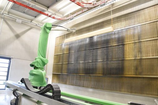 Nach dem Zwischenschliff per Hand erfolgt die Vor- bzw. Endlackierung durch einen Lackierroboter. 