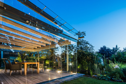 Der gläserne Anbau von Solarlux schafft bereits im Frühjahr und Herbst ein gemütliches Plätzchen im Garten.