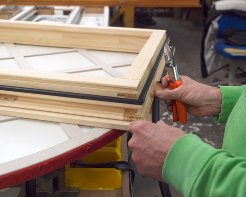 Nach der Oberflächenbehandlung setzt Joachim Kleinert die Dichtungen ein und schneidet an den Ausfräsungen für die Zuluft die Dichtung aus.