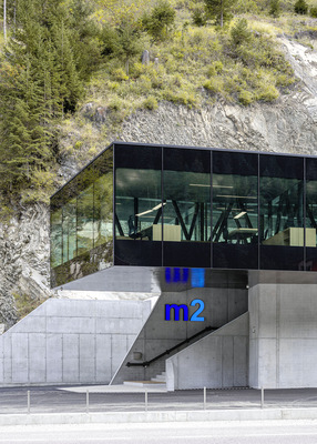 Das Gebäude der m2 Railgroup schmiegt sich seitlich an den Berg und folgt in seiner Form den natürlichen Gegebenheiten der Landschaft.