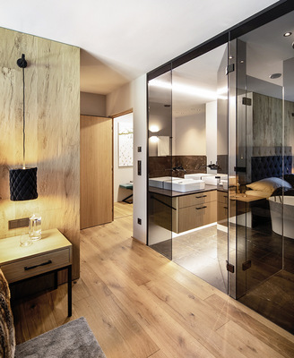 Die elegante Glaswand öffnet sich zum Schlafzimmer.