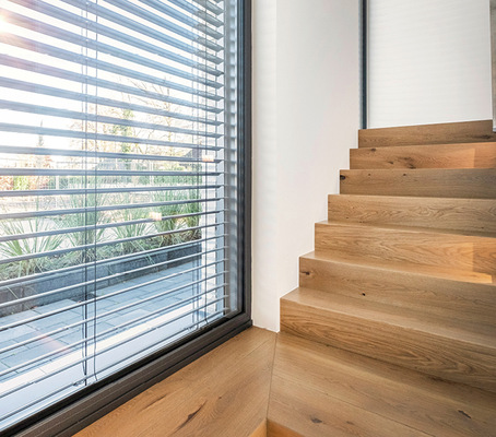 Durch eine spezielle Lamellenneigung funktioniert der Hitze-, Blend- und Sonnenschutz der Raffstoren mit ProVisio bei gleichzeitig optimaler Durchsicht von ­innen.