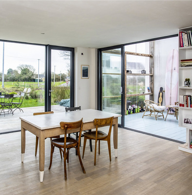 Blick durch den an den Wintergarten grenzenden Wohnbereich. Großzügige ­Glasflächen an den Fassaden lassen viel Tageslicht in den Raum.