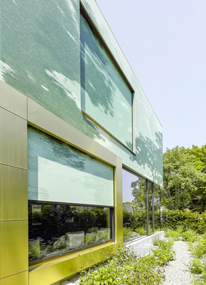 Im Obergeschoss wurde ein bedruckter Textilumhang aus graugrünem wetterfestem Stoff vor die Verglasung gespannt.