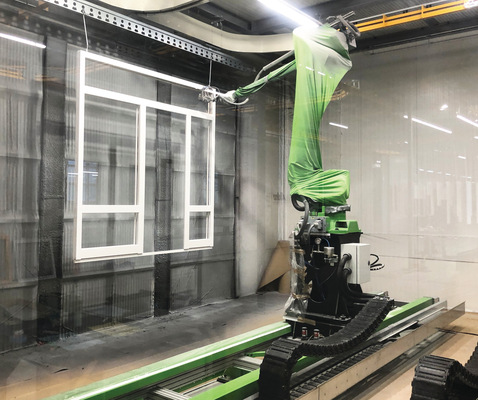 Die Lackierung im Spritzverfahren erfolgt über zwei Roboter, die auf Verfahrwagen montiert sind. Mit einer 3D-Erkennung ausgestattet, ermitteln sie zunächst die Beschaffenheit, wie beispielsweise die Profilstärke der Elemente, um dann die Farbe in einem optimierten Lackierbewegungsablauf gleichmäßig aufzutragen.