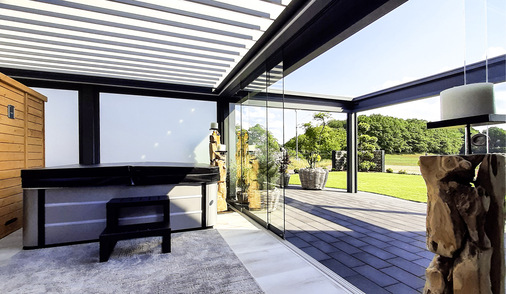 Der Bereich unter dem Lamellendach beinhaltet Sauna und Whirlpool. Der äußere mit der Pergola kann vollständig geöffnet werden.