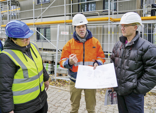  Josef Huber (GF ­Huber & Sohn) erklärt anhand von Konstruktions­details die Lösung der Brandschutz­anforderung. (v. l. n. r. Anyke ­Aguirre Cano (ift), Josef Huber und Projektleiter ­Martin Nachtwey (Huber & Sohn))