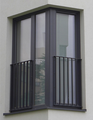  Über Eck geführtes Fenster. Das hier eingesetzte Ergänzungsprofil ist nicht sichtbar, da es mit einer Vorsatzschale (anthrazitfarbenes Blech) verblendet ist und dient für die Verbindung (Koppeln) der Fenster sowie für das Anbringen eines gegen Absturz sichernden Gitters (französischer Balkon).