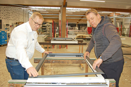  Hubert Hilbring (li.), Produktmanagement und Programmierung, sowie Jürgen Venhaus clipsen den Aluminiumrahmen auf das moderne Kunststofffenster.